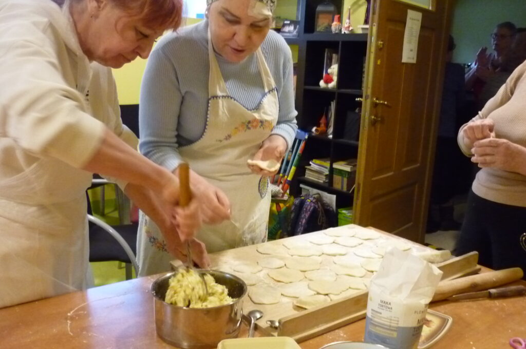 Nasza ekipa przy pracy. Widać już narobione placki na pierogi i właśnie jest ugniatany farsz.